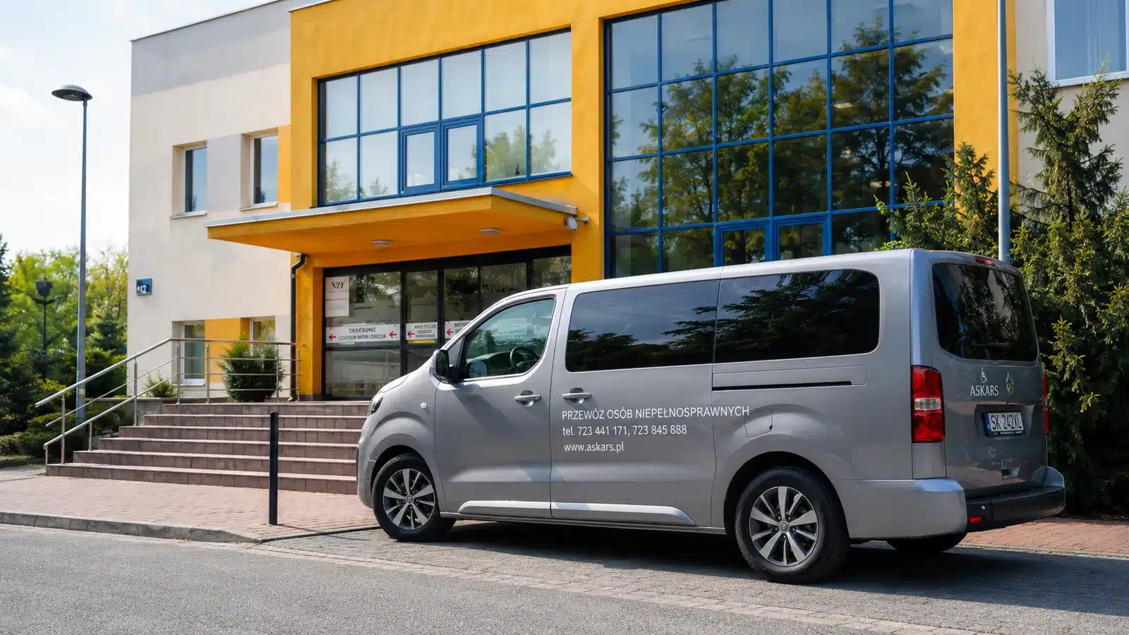 Samochód ASKARS przystosowany do transportu osoby na wózku przed szpitalem